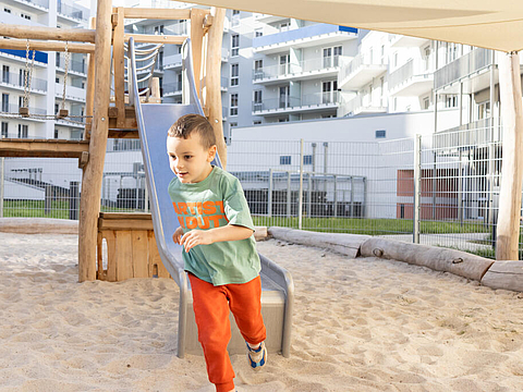 Ein Kind spielt auf dem Spielplatz mit einer Rutsche