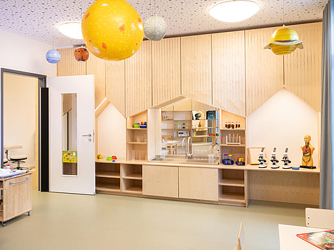 Im Forscherraum gibt es ein Anatomiemodel, Mikroskope und ein Kinderchemielabor. An der Decke hängt ein Model des Sonnensystems. 