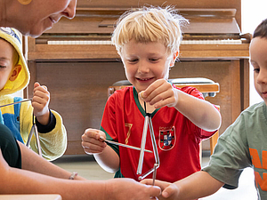 Kinder musizieren mit Triangeln
